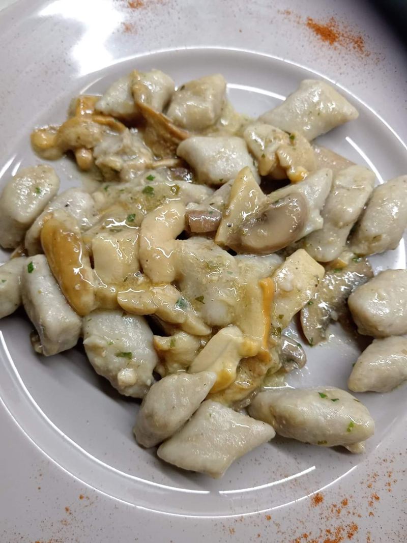Piatto di gnocchi ai funghi con prezzemolo e paprika sul bordo