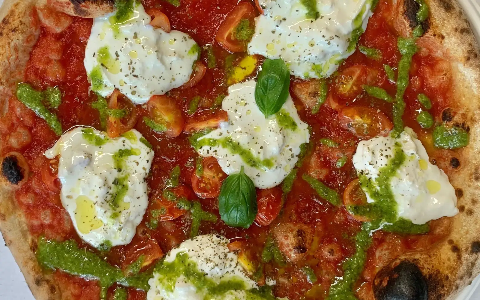 Mysticpizza Ligure appena sfornata: pomodorini, stracciatella, basilico e pesto genovese