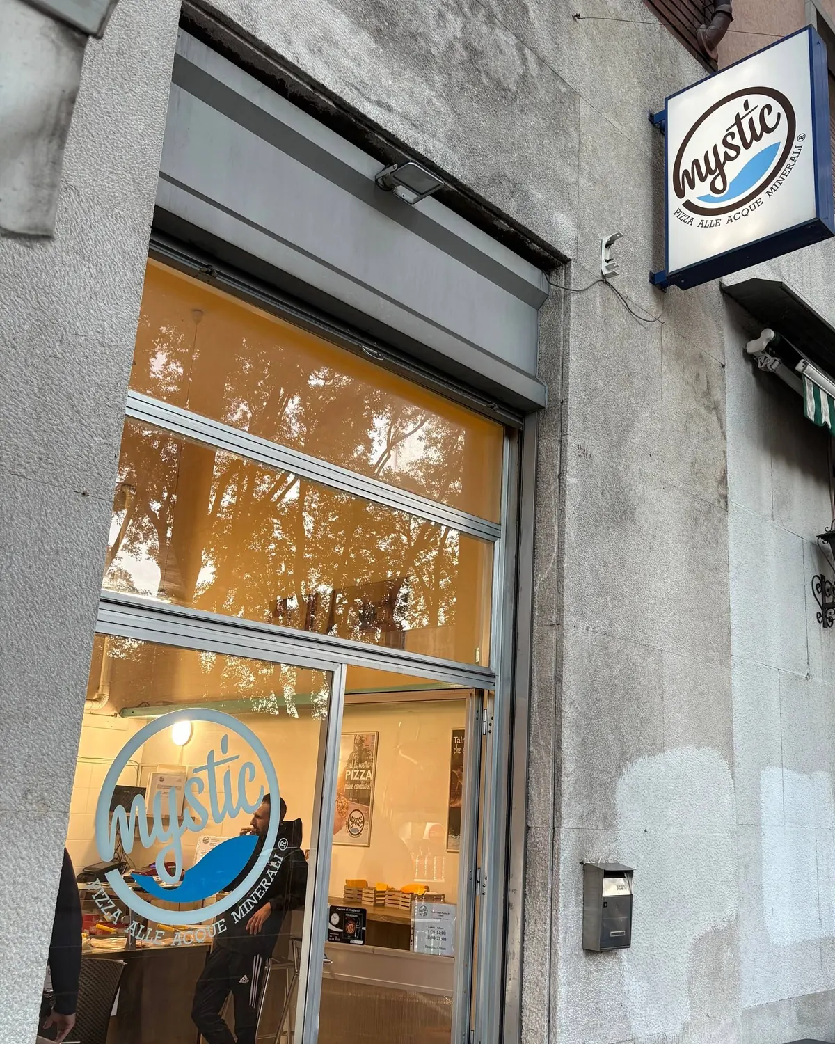 L’ingresso di Mystic Pizza in Via di Campo Marzio 20 a Trieste, con l’insegna e il logo sulla vetrina