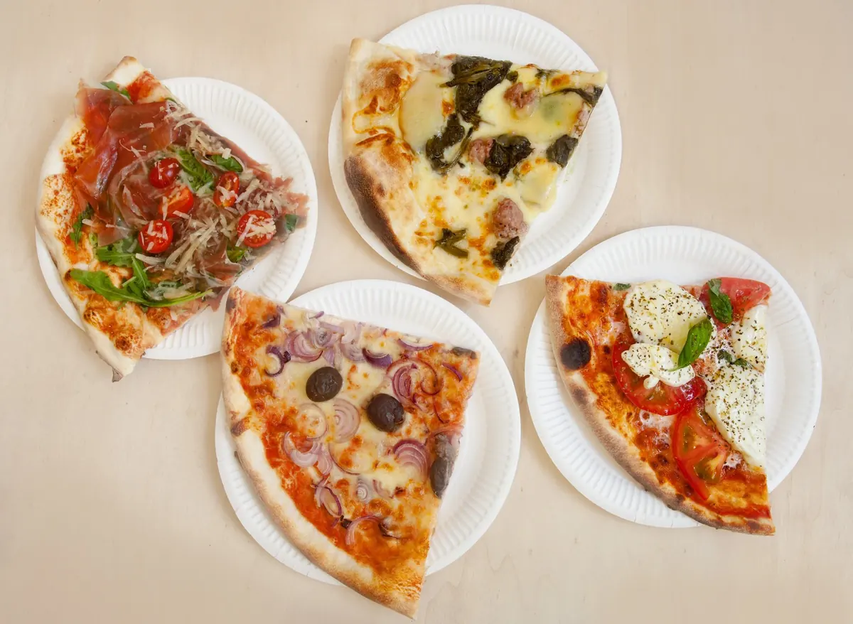 Tranci di pizza Mystic su piatti di carta, pronti da portare via